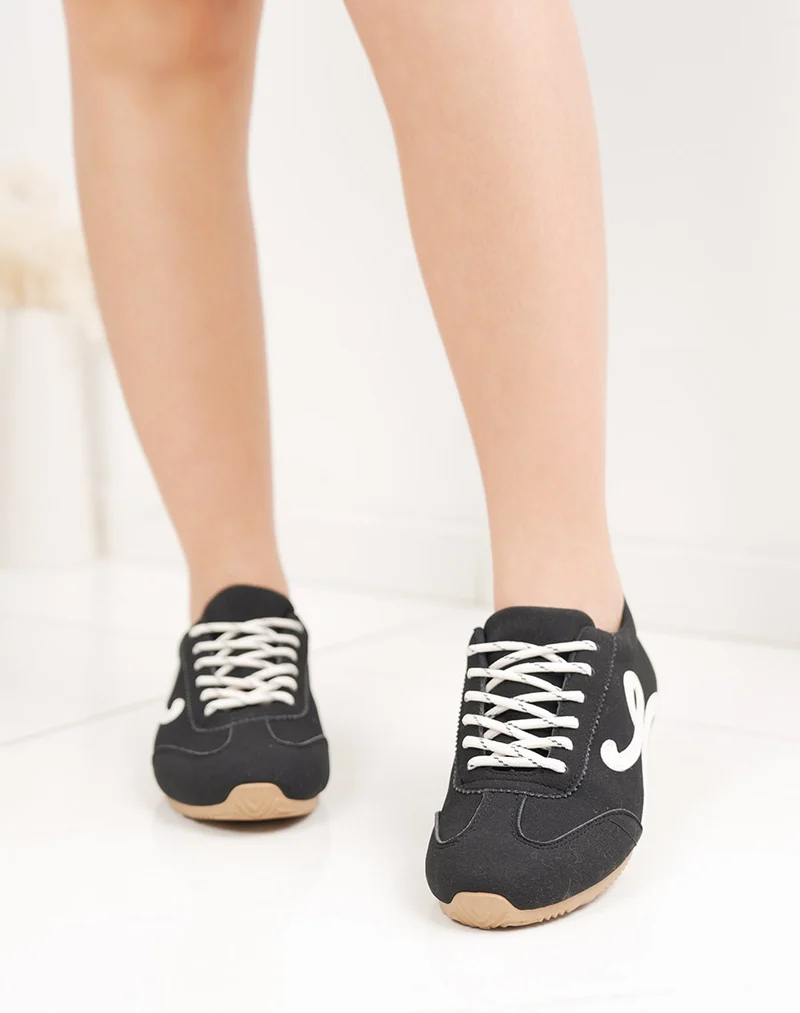 Basket femme noire élégante à lacets blancs avec empiècements contrastés