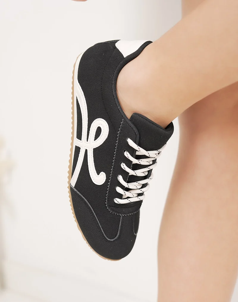 Basket femme noire élégante à lacets blancs avec empiècements contrastés