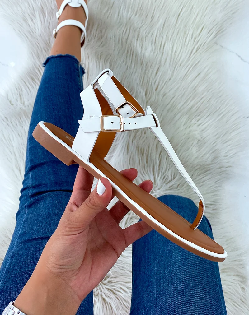 Nu-pieds blancs à double lanière et boucles dorées